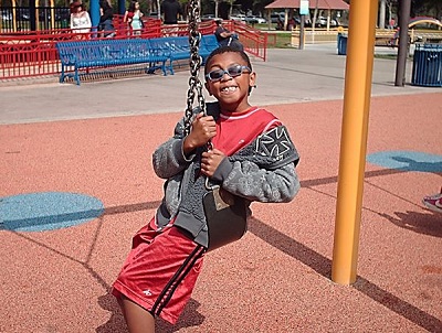 a teen playing on the swings at the sensory playground